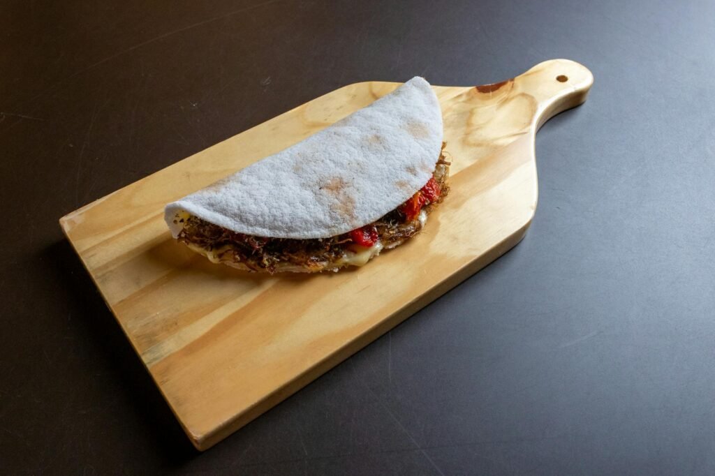 Para fazer tapioca perfeita em casa, comece hidratando a goma de tapioca com água e sal, peneire para eliminar grumos e aqueç